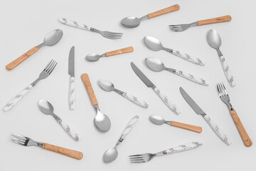 Set of stainless steel cutlery with plastic handles on white background