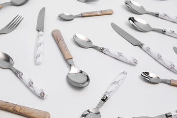 Set of stainless steel cutlery with plastic handles on white background, closeup