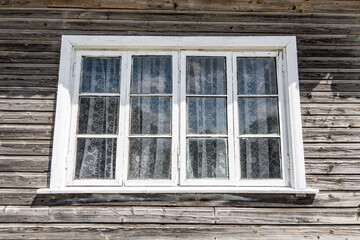 Fototapeta na wymiar White wooden window frame in an old wooden house