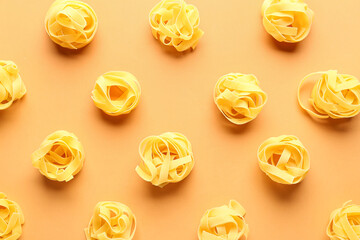 Composition with uncooked tagliatelle pasta on beige background
