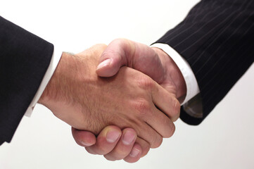 Close-up on handshake of two unrecognizable businessmen. Isolated handshake on white background. Concept of business, agreement, deal made, trust or customer satisfaction