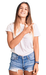 Obraz premium Beautiful caucasian woman wearing casual white tshirt cheerful with a smile on face pointing with hand and finger up to the side with happy and natural expression