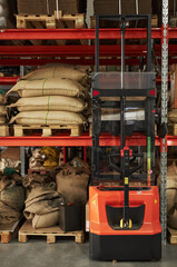 Vertical background image of warehouse shelves with bags of coffee and forklift mover equipment