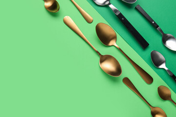 Different stylish spoons on color background