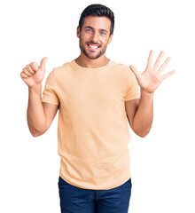 Naklejka premium Young hispanic man wearing casual clothes showing and pointing up with fingers number six while smiling confident and happy.