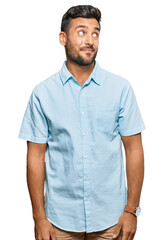 Fototapeta premium Handsome hispanic man wearing casual clothes smiling looking to the side and staring away thinking.