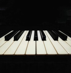 Closeup of piano keys on a black background