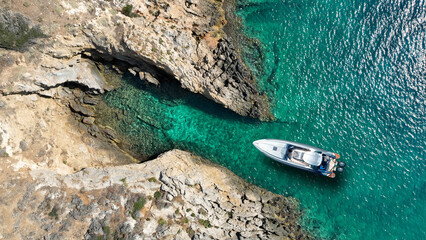 Aerial drone top down photo with copy space of inflatable speed boat anchored in tropical exotic rocky island with emerald crystal clear sea © aerial-drone