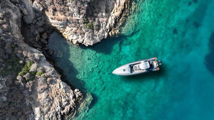 Aerial drone top down photo with copy space of inflatable speed boat anchored in tropical exotic rocky island with emerald crystal clear sea © aerial-drone