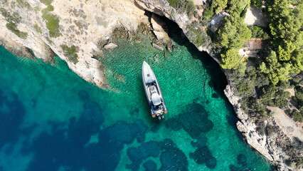 Aerial drone top down photo with copy space of inflatable speed boat anchored in tropical exotic rocky island with emerald crystal clear sea © aerial-drone