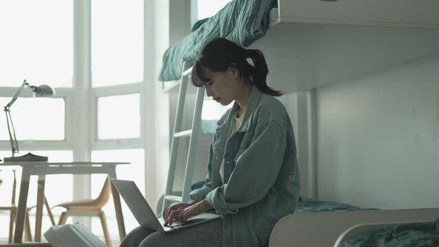 young asian student woman doing lesson exam at college dormitory.