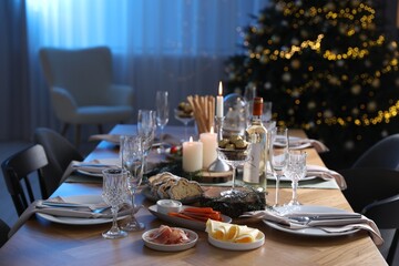 Christmas table setting with festive decor and dishware in room