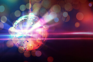 Shiny disco ball on dark background with blurred lights, space for text. Bokeh effect