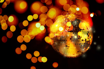 Shiny disco ball on black background with blurred lights, bokeh effect