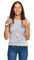 Young african american girl wearing casual clothes success sign doing positive gesture with hand, thumbs up smiling and happy. cheerful expression and winner gesture.