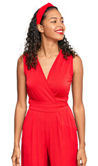 Young african american girl wearing elegant and sexy look looking away to side with smile on face, natural expression. laughing confident.