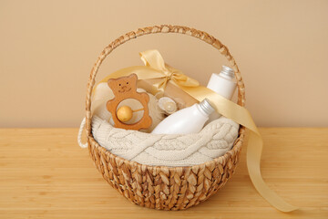 Gift basket for baby on table near beige wall in room