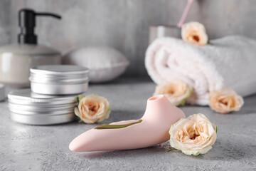 Vibrator with flowers on grunge table, closeup