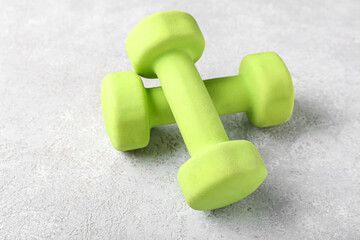 Green dumbbells on grey background