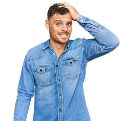 Young hispanic man wearing casual denim jacket confuse and wonder about question. uncertain with...
