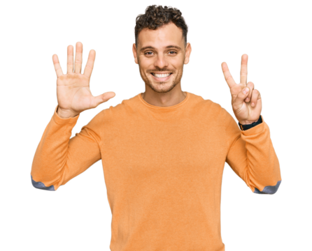 Young hispanic man wearing casual clothes showing and pointing up with fingers number seven while smiling confident and happy.