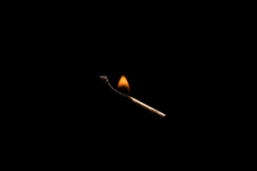 Lit falling match on a black background.