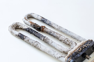 Old electric tubular heater broken with calcareous plaque, selective focus