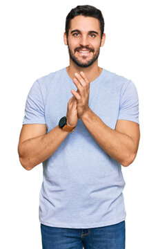 Young hispanic man wearing casual clothes clapping and applauding happy and joyful, smiling proud hands together