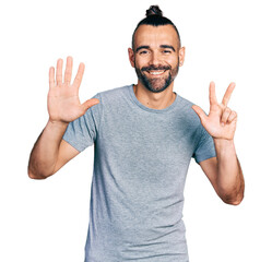 Fototapeta premium Hispanic man with ponytail wearing casual grey t shirt showing and pointing up with fingers number eight while smiling confident and happy.