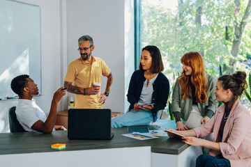 A multicultural chief having meeting at office with his diverse employees.