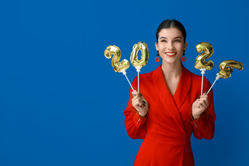 Beautiful young happy woman with figure 2024 made of balloons on blue background. Chinese New Year...