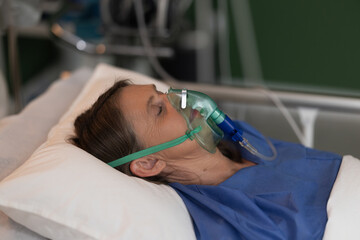 Portrait of senior woman in hospital bed, wearing oxygen mask, in a peaceful unconscious state.