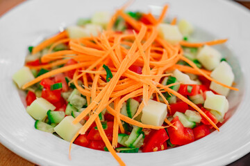 vegetable salad of carrots, cucumbers and tomatoes, close-up, selective focus
