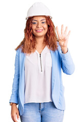 Young latin woman wearing architect hardhat showing and pointing up with fingers number four while smiling confident and happy.