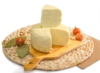 Round cut Adyghe cheese on a woven napkin on a white background