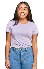 Young latin woman wearing casual clothes smiling looking to the side and staring away thinking.