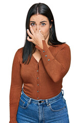 Young hispanic woman wearing casual clothes smelling something stinky and disgusting, intolerable...