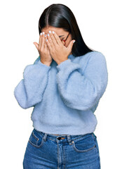 Young hispanic woman wearing casual clothes and glasses with sad expression covering face with...