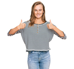 Obraz premium Beautiful blonde woman wearing casual clothes success sign doing positive gesture with hand, thumbs up smiling and happy. cheerful expression and winner gesture.