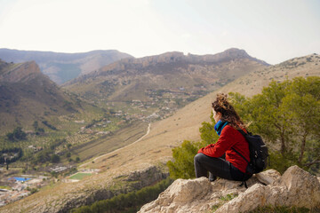 Fototapeta premium Relaxed mature woman on top of a hill and looking at the city