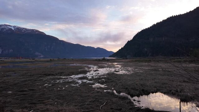 Wetlands surrounded by Mountains in Canadian Nature. Fall Season, Sunset Sky. Squamish, British Columbia Canada.