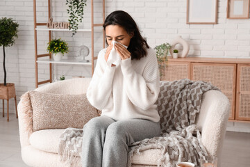 Sick young woman with tissue at home