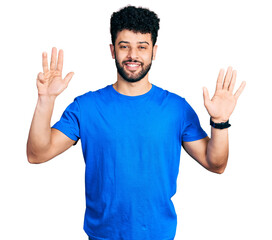 Fototapeta premium Young arab man with beard wearing casual blue t shirt showing and pointing up with fingers number nine while smiling confident and happy.