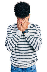 Young arab man with beard wearing casual striped sweater rubbing eyes for fatigue and headache,...