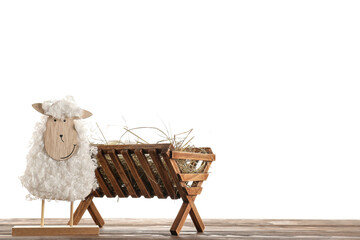 Manger with baby and toy sheep on table against white background. Concept of Christmas story - Powered by Adobe