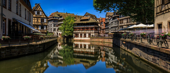 Fototapeta na wymiar Ornate traditional half timbered houses with blooming flowers along the canals in the picturesque Petite France district of Strasbourg, Alsace, France