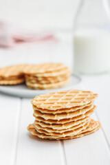 Round waffle biscuits on white table.