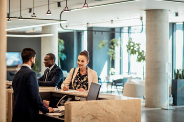 Businesswoman signing document at hotel front desk