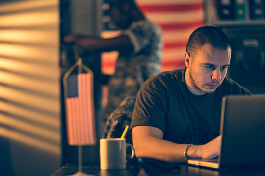 Army soldier working on laptop at military base