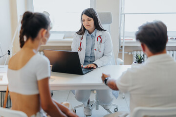 Fototapeta premium Successful Doctors Discussing Medical Results with a Couple in Clinic